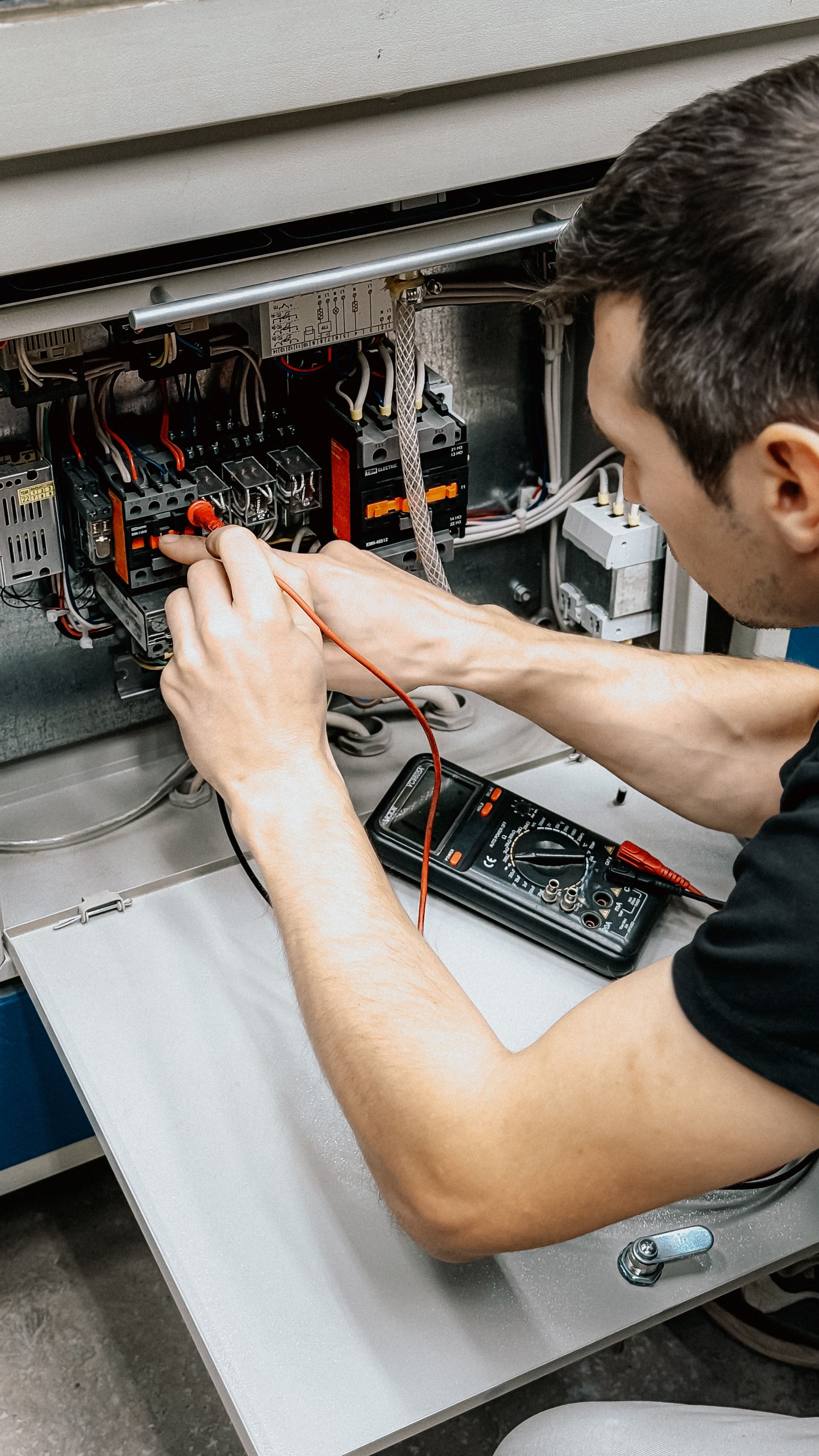 Electrician checking wiring inside a consumer unit